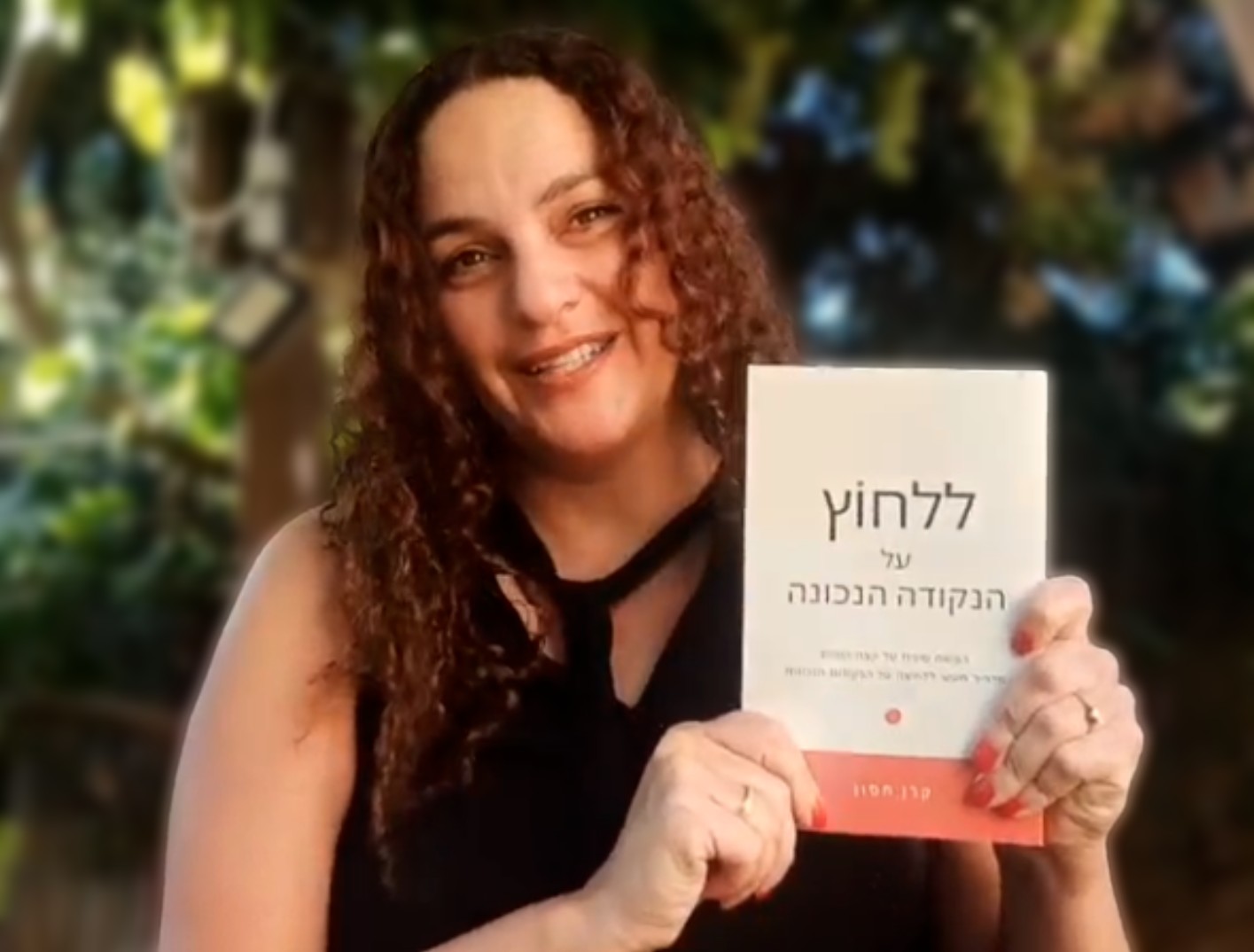 קרן חסון מחזיקה את ספרה ללחוץ על הנקודה הנכונה